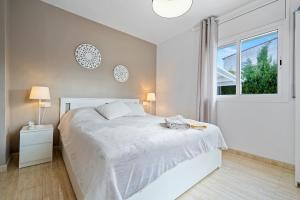 a white bedroom with a bed and a window at Las Palmeras in Tarragona +23 photos
