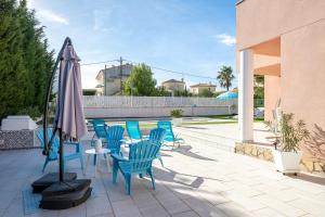 a patio with a table and chairs and an umbrella at Las Palmeras in Tarragona