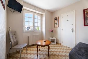 a small room with a table and a bed and a window at La Mansardière in Cancale