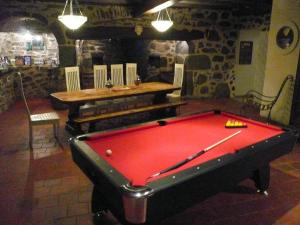 a pool table in a room with a table and bench at Guidon Fourchette et table d'hôtes in Saint-Bonnet-de-Salers