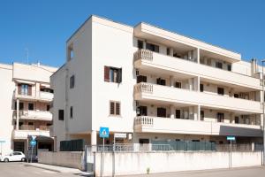 a white apartment building with a white car parked in front at Casa Manuela in Lecce