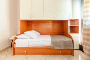 a bed with a wooden headboard and white cabinets at Casa Manuela in Lecce