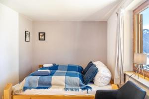 a bedroom with a bed with a blue and white blanket at Sonnenhütte Wildschönau Erdgeschoß in Grafenweg