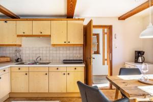 a kitchen with wooden cabinets and a table with chairs at Sonnenhütte Wildschönau Erdgeschoß in Grafenweg +15 photos