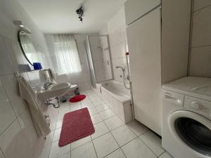 a bathroom with a sink and a washing machine at Ferienwohnung - Haus Waibel in Überlingen
