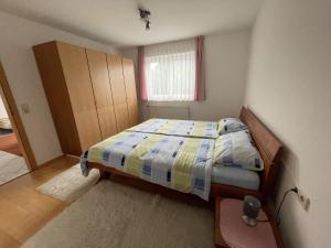 a small bedroom with a bed and a window at Ferienwohnung - Haus Waibel in Überlingen