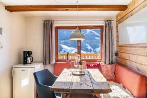 a dining room with a table and a large window at Sonnenhütte Wildschönau Erdgeschoß in Grafenweg