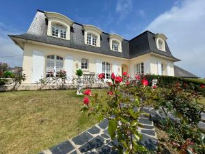 a house with red roses in the yard at La Mansardière in Cancale