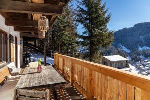 a wooden deck with a table and chairs on a balcony at Sonnenhütte Wildschönau Erdgeschoß in Grafenweg
