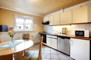 a kitchen with a table and a counter top at Ferienwohnung Hildegard in Rappersweier