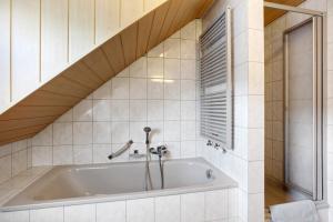 a bath tub in a bathroom with a wooden ceiling at Ferienwohnung Hildegard in Rappersweier +16 photos