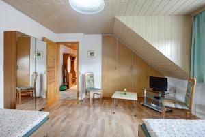 a room with a bed and a desk with a television at Ferienwohnung Hildegard in Rappersweier