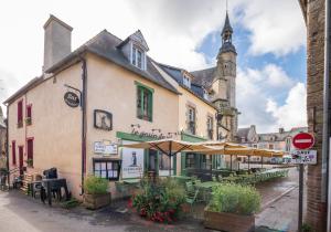a building with tables and umbrellas on a street at Petite Maison Malestroyenne in Malestroit