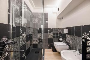a black and white bathroom with a toilet and a sink at Appartamento Mazzin in Mazzin +27 photos
