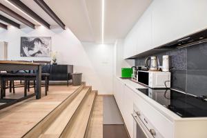 a kitchen with white cabinets and a dining table at Appartamento Mazzin in Mazzin