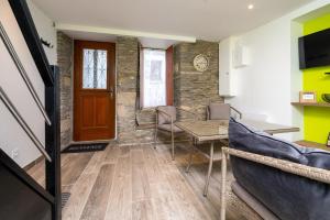a living room with a table and chairs and a door at Petite Maison Malestroyenne in Malestroit