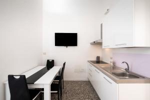 a kitchen with a sink and a table with chairs at Suite Biancolino in Nardò +11 photos
