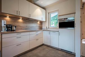a kitchen with white cabinets and a window at Sommersbergerhof 1968 in Bressanone