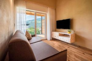 a living room with a couch and a flat screen tv at Sommersbergerhof 1968 in Bressanone