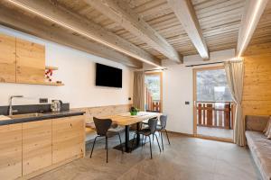 a kitchen and dining room with a table and chairs at Lòni Lodge Vermiglio in Vermiglio