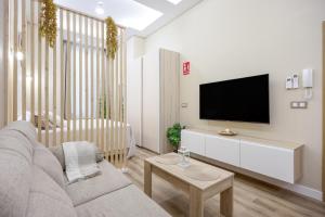 a living room with a couch and a flat screen tv at Apartamentos Brisas de Cádiz 3 in Cádiz