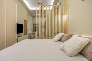 a bedroom with a large white bed and a television at Apartamentos Brisas de Cádiz 3 in Cádiz