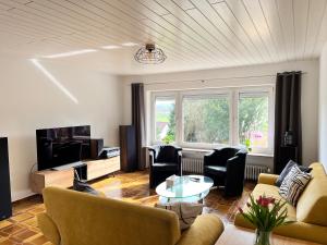 a living room with a couch and chairs and a table at Terrasse mit Ausblick in Biedenkopf
