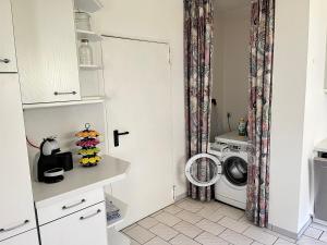 a laundry room with a washer and a washing machine at Terrasse mit Ausblick in Biedenkopf +17 photos
