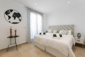 a white bedroom with two beds and a window at Stunning apartment in Cómpeta in Cómpeta