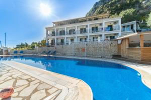 a large swimming pool in front of a building at Captain Spiros Studios 2 in Paleokastritsa