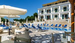 a resort with a pool and chairs and a building at Captain Spiros Studios 2 in Paleokastritsa