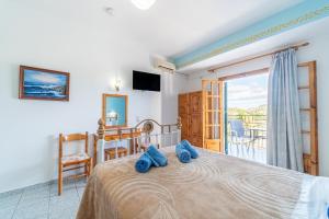 a bedroom with a bed with blue towels on it at Captain Spiros Studios 2 in Paleokastritsa