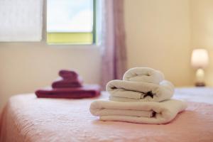 a pile of towels sitting on top of a bed at Levada Residence in Funchal +12 photos