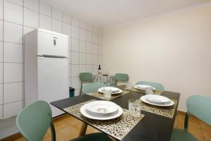 a dining room with a table and chairs and a refrigerator at Levada Residence in Funchal