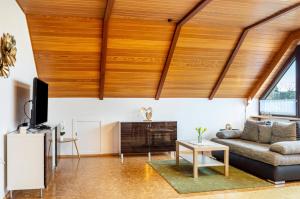 a living room with a large wooden ceiling at Fewo Naturblick in Wiesenthau