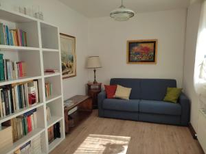 a living room with a blue couch and a book shelf at La Casetta Gialla in Pieve di Cadore