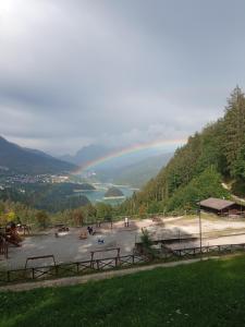 a rainbow over a lake with a group of people at La Casetta Gialla in Pieve di Cadore