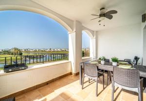 a balcony with a table and chairs and a view of the water at Casa verde in Roldán
