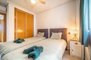 two beds in a bedroom with blue towels on them at Casa verde in Roldán +14 photos