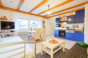 a large kitchen with blue cabinets and a table at Ferienwohnung Martin Lehmann in Oberharmersbach