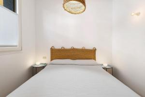 a bedroom with a white bed with two tables at U Canetta 1 in Pietra Ligure