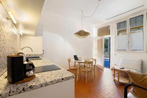 a kitchen with a counter and a dining room with a table at U Canetta 1 in Pietra Ligure
