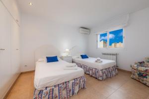 two beds in a white room with a window at Villa Can Gaya in Alcudia +22 photos