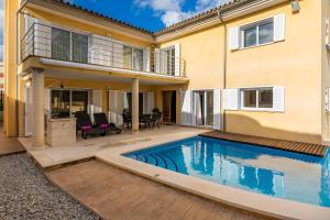 a swimming pool in front of a house at Villa Can Gaya in Alcudia