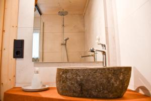 a bathroom with a stone sink and a mirror at Panoramahisli 3 in Fischerbach
