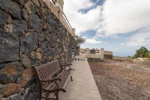 a bench sitting next to a stone wall at La Generosa in Arona