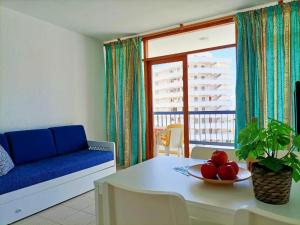 a living room with a couch and a table with a bowl of fruit at Casa Marazul in Playa Fañabe