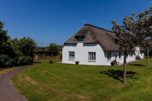a large white house with a thatched roof at Dat Möhlenhus Peter Jensen in Pellworm