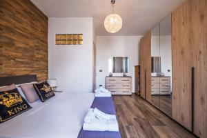 a bedroom with a large bed and a wooden wall at Narcê – Coastal Retreat in Porto Cesareo