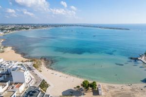 an aerial view of a beach with people in the water at Narcê – Coastal Retreat in Porto Cesareo